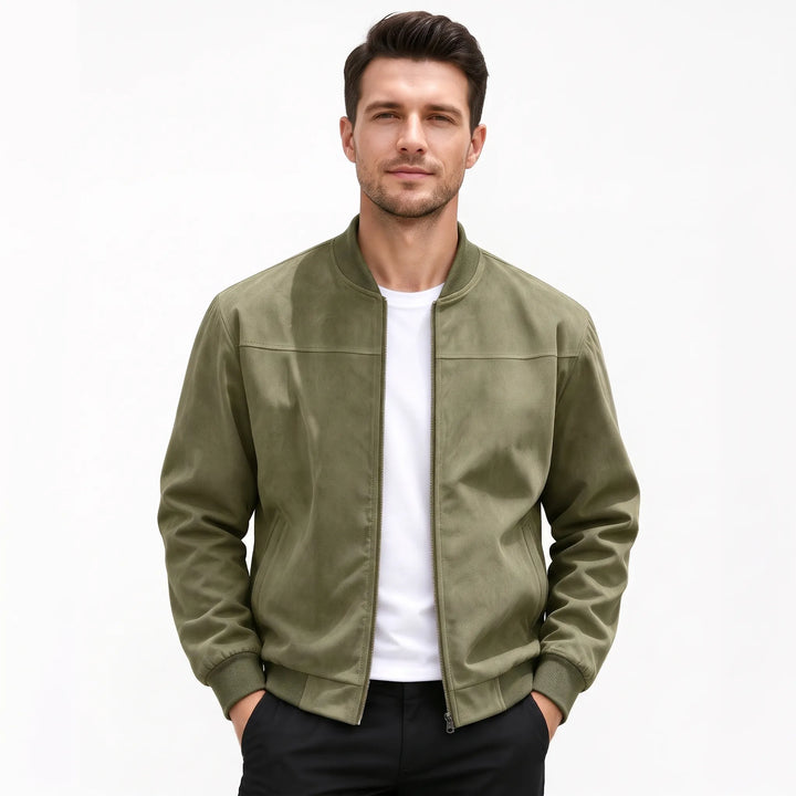 Studio shot of a man in the olive green bomber jacket, hands in black pants pockets 53
