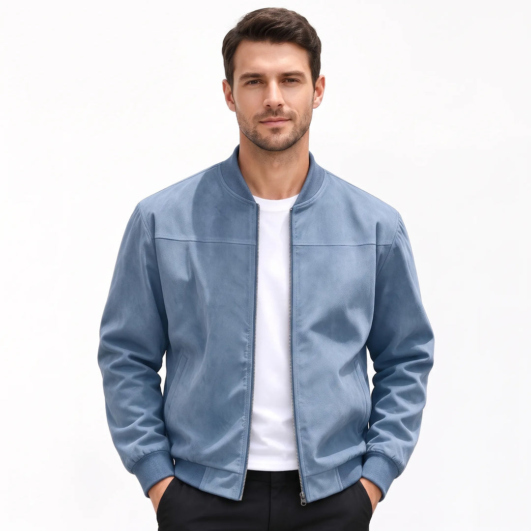 Studio shot of a man in the dusty blue bomber jacket, hands in black pants pockets 54