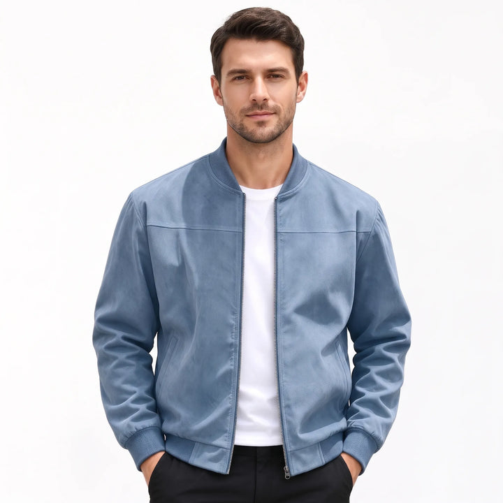 Studio shot of a man in the dusty blue bomber jacket, hands in black pants pockets 54