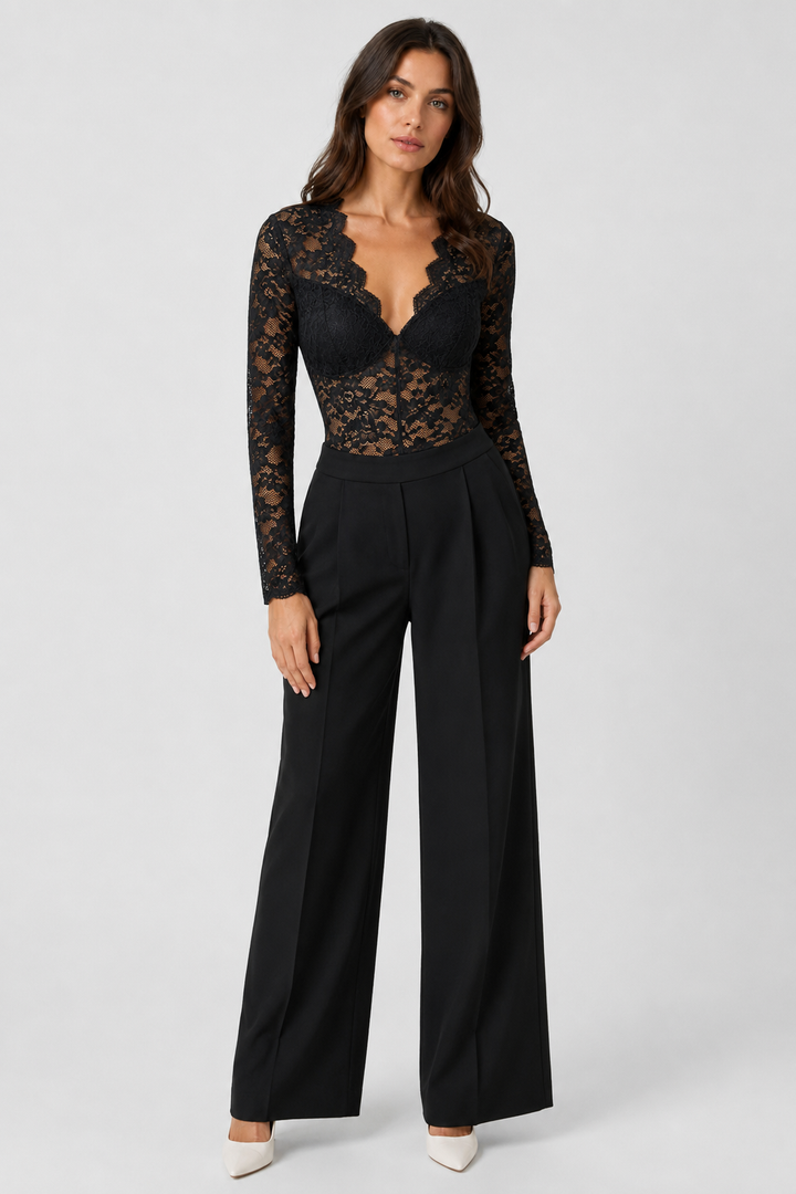 Full-length front view of the black lace bodysuit styled with high-waisted black wide-leg trousers and white pointed heels 2