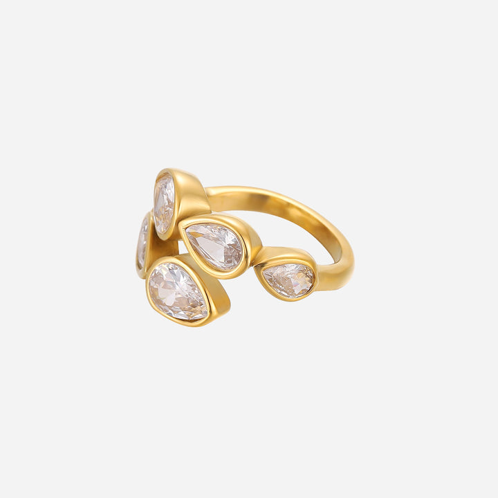 Gold-tone open ring with five clear pear-shaped crystals in bezel settings, shown from the side on a plain light background. 1