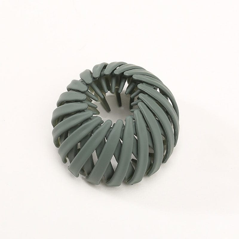 Twist-and-snap hair clip in muted sage green velvet shown from above.