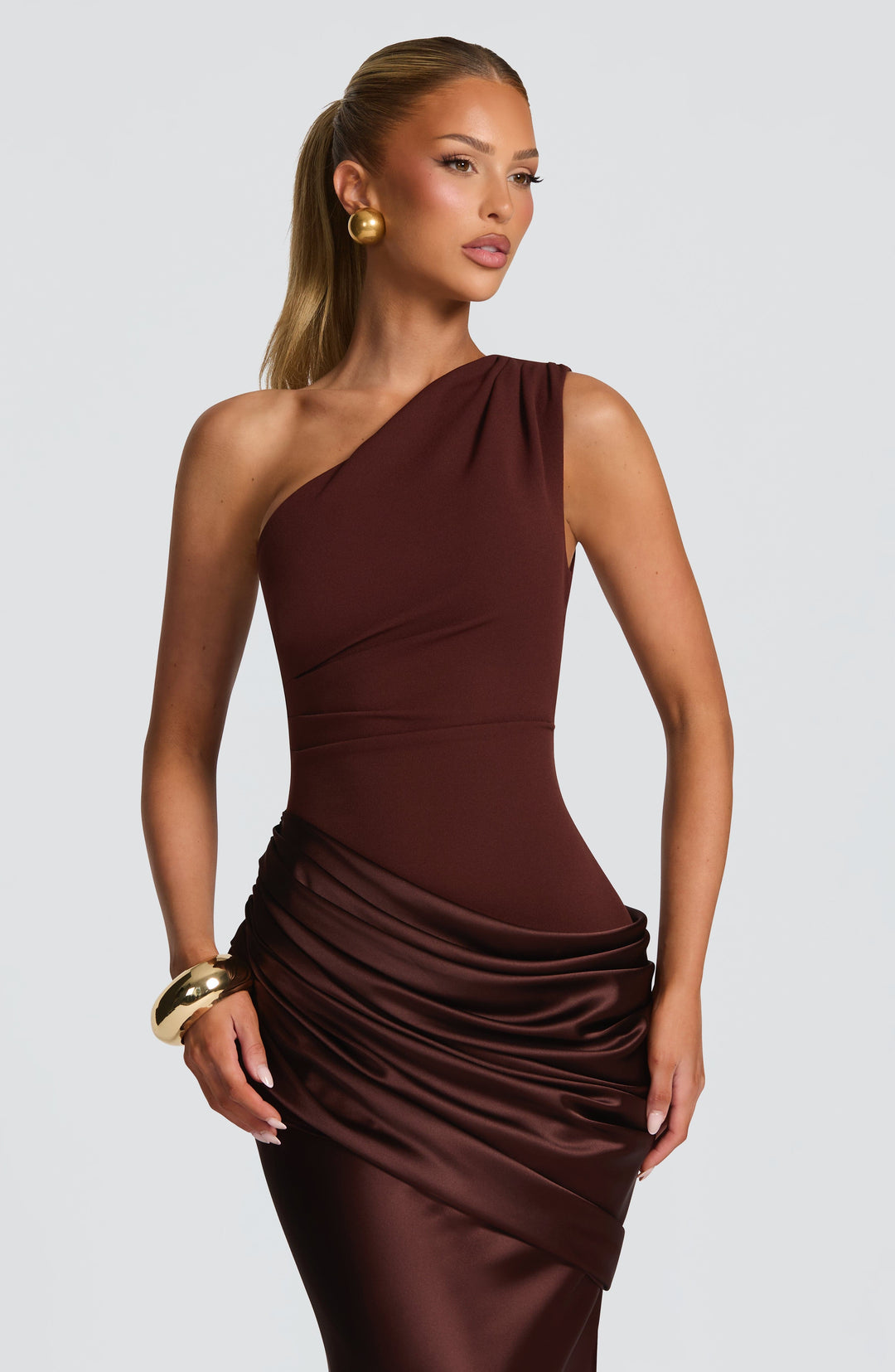 Close-up of the brown gown's one-shoulder neckline, fitted bodice and glossy satin ruching at the hip. 7