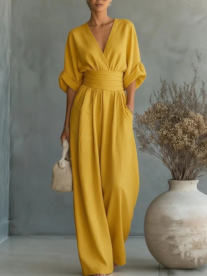 Mustard yellow women's jumpsuit with cuffed short sleeves and wide legs.