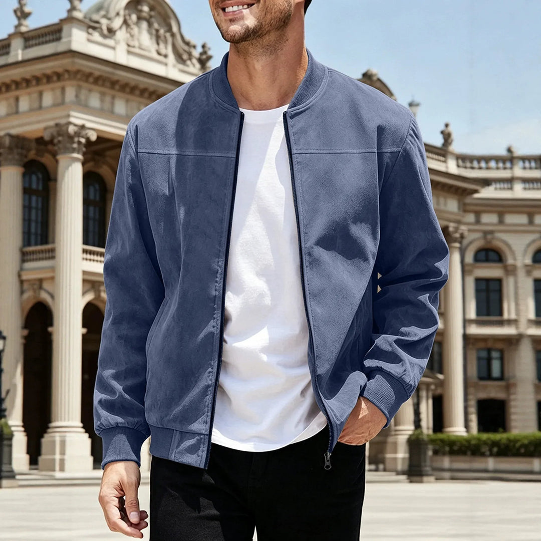 Man in a blue zip-up jacket over a white tee, walking in front of a classical building 5
