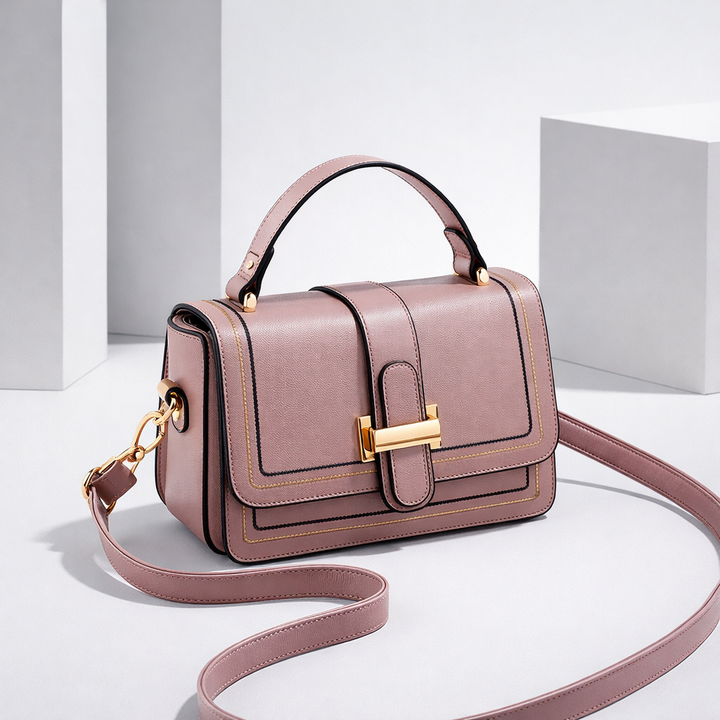 Dusty mauve-pink version of the bag with gold clasp, angled studio view with the strap curving across the floor. 7