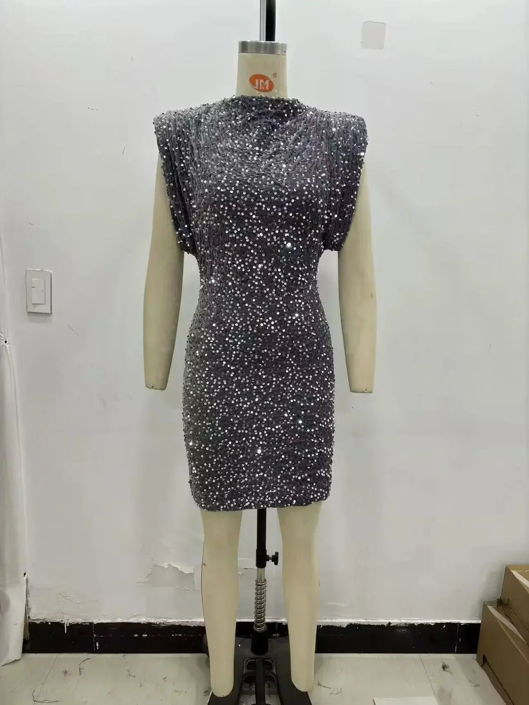 Gray sequined mini dress displayed on a dress form against a plain wall 5