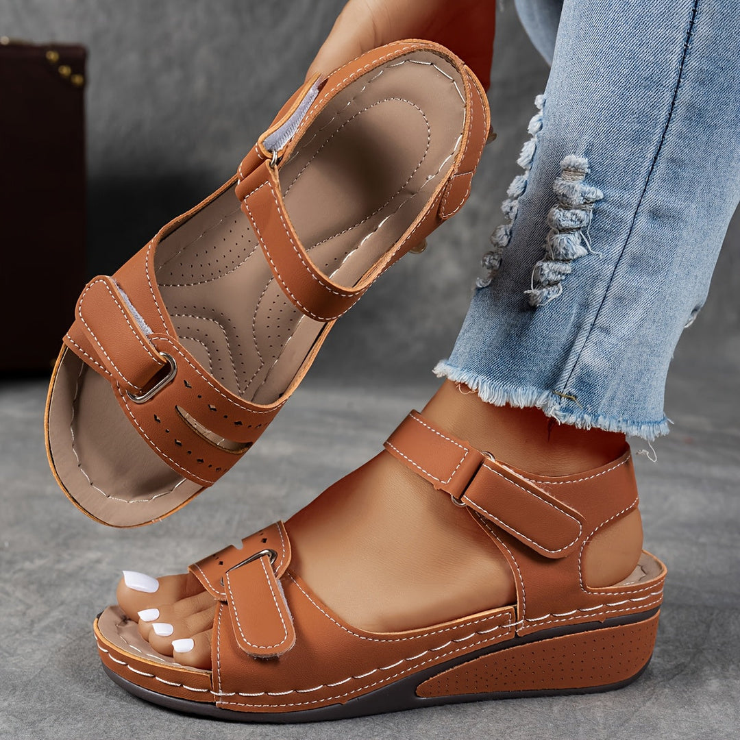 Brown wedge sandal with cream stitching and hook-and-loop straps, with the contoured footbed visible. 5