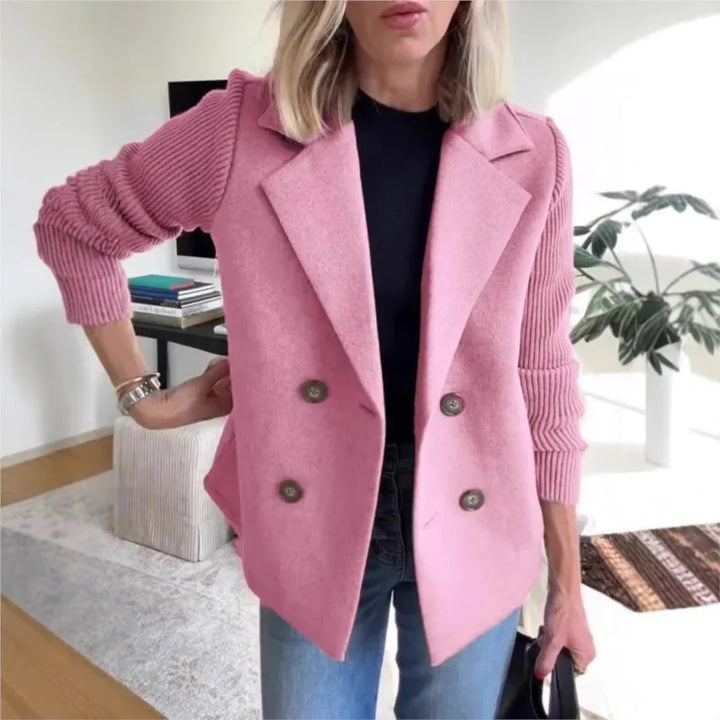 Pink double-breasted jacket with ribbed knit sleeves, worn over a black top with jeans indoors 5