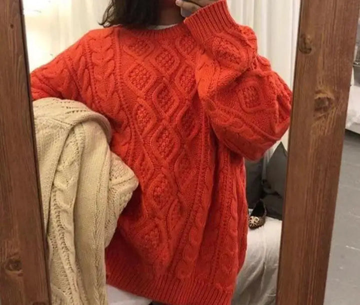 Frau in rotem Strickpullover mit Zopfmuster, hält beigen Pullover, gemütliche Wintermode.