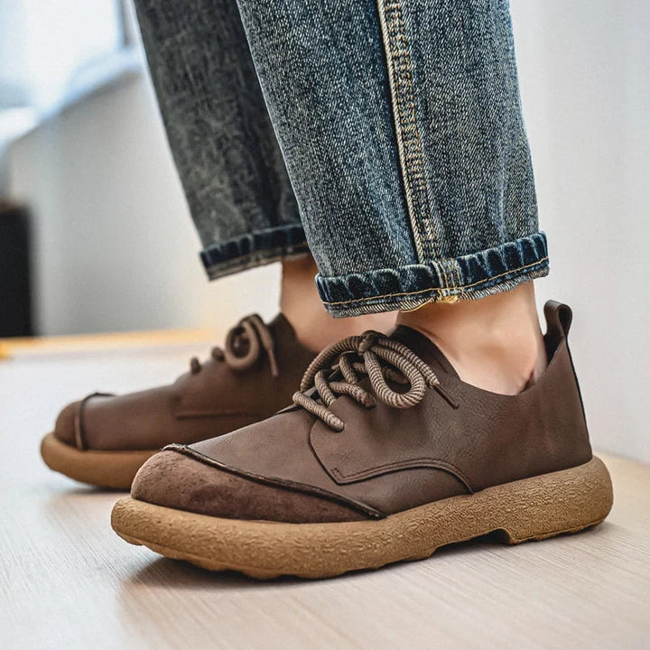 Dark brown lace-up shoes worn with rolled-cuff jeans, showing the contrasting suede toe cap 5