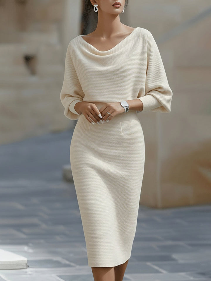 Model wearing the cream ribbed knit dress with draped neckline and three-quarter sleeves, front view 3