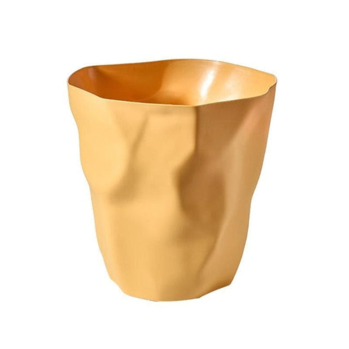 Brown wastebasket with a sculptural crumpled paper design and rippled uneven opening.
