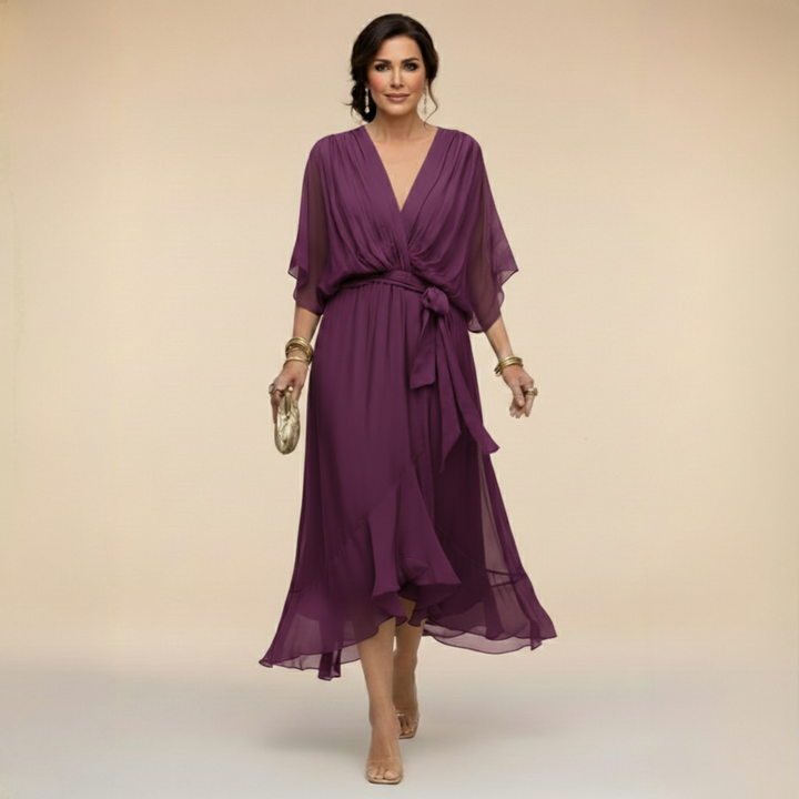 Plum purple midi dress detail with a pleated wrap-style bodice and tied sash.