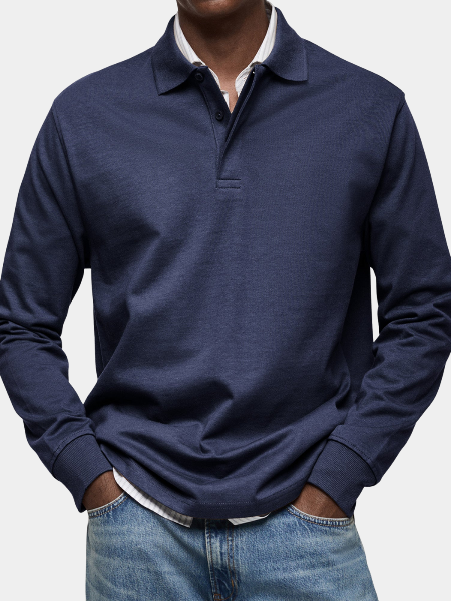 Man wearing the navy long sleeve polo shirt over a striped shirt, close crop showing collar, buttons and ribbed cuffs.