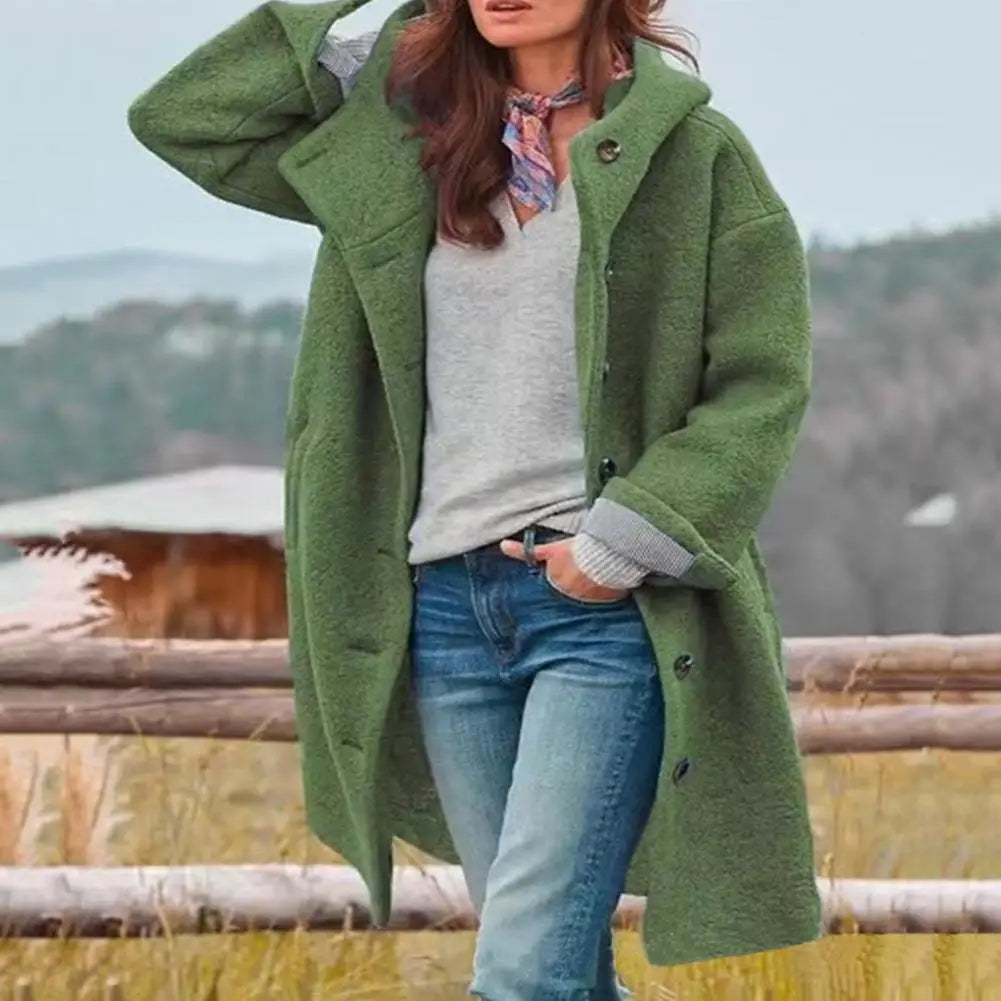 Green hooded coat styled with a patterned neck scarf and jeans, outdoors by a fence 5
