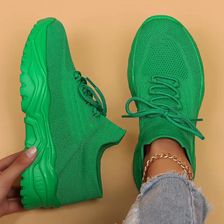 Solid green knit sneakers with green laces and chunky green soles, top-down view.