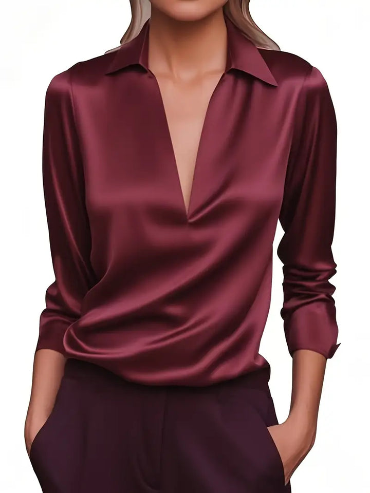 Model wearing the long-sleeve satin blouse in burgundy with a deep V-neck and collar.