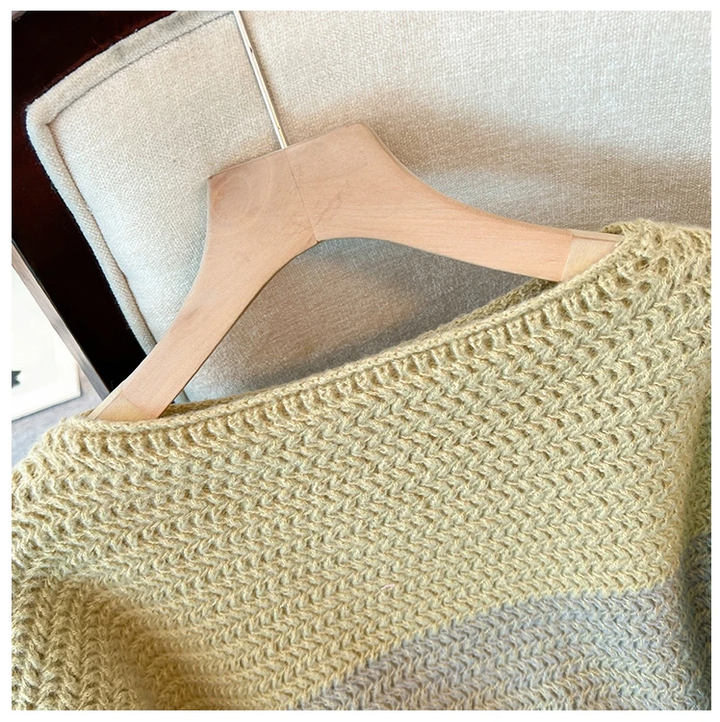 Beiger Strickpullover auf Holzkleiderbügel, Nahaufnahme, weiches Material, modisch, gemütlich.