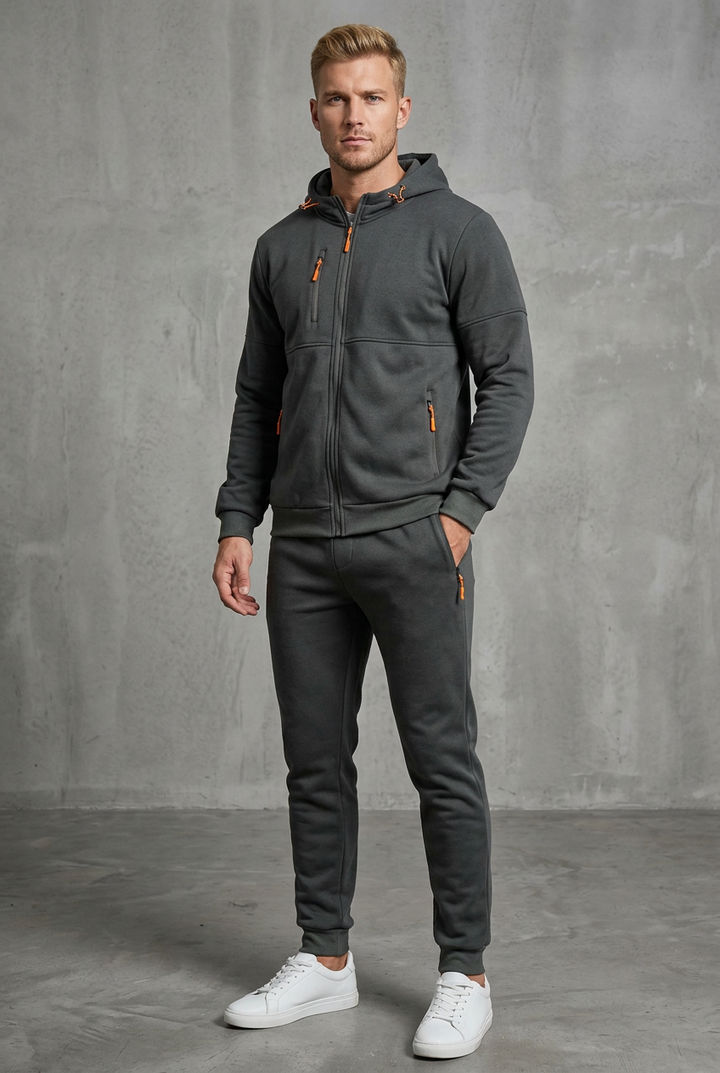 Front view of a man in a dark gray zip hoodie and joggers with orange zipper pulls 4
