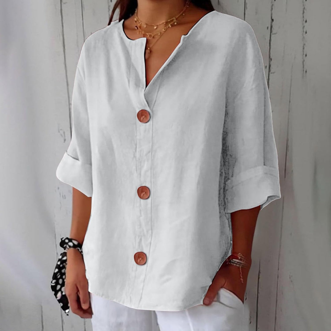 Olivia loose linen blouse in white with a notched V-neck, three brown buttons and cuffed half sleeves.