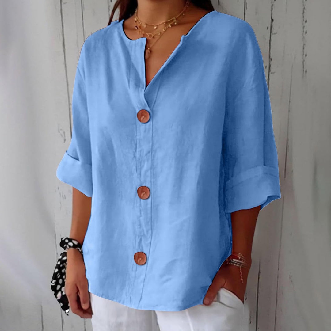 Olivia loose linen blouse in light blue with a notched V-neck, three wooden buttons and cuffed half sleeves.