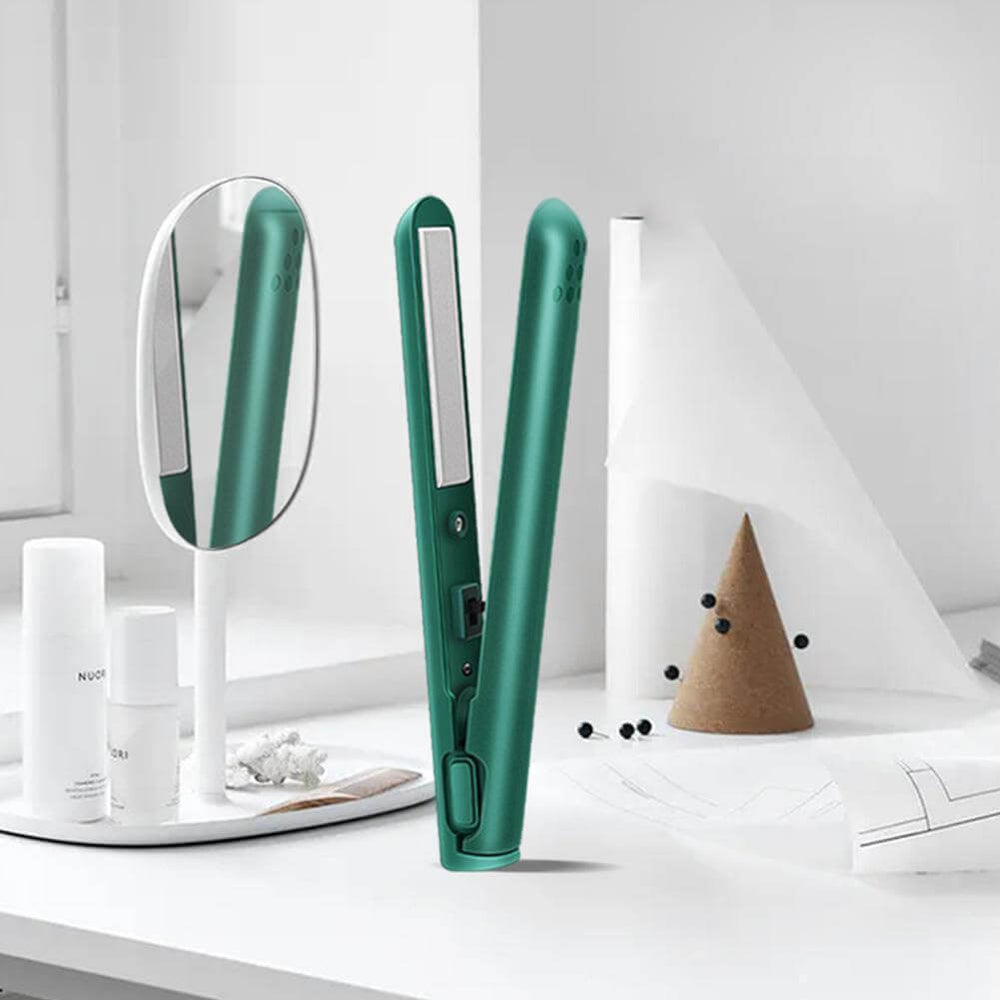 Open green mini straightener standing on a white vanity beside a round mirror and white bottles 2