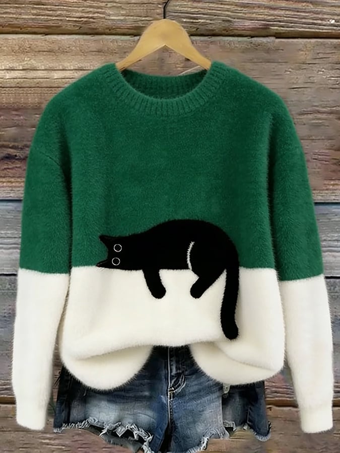 Green and white fuzzy colorblock sweater with a black cat resting on the color line, hung against a rustic wooden backdrop. 5