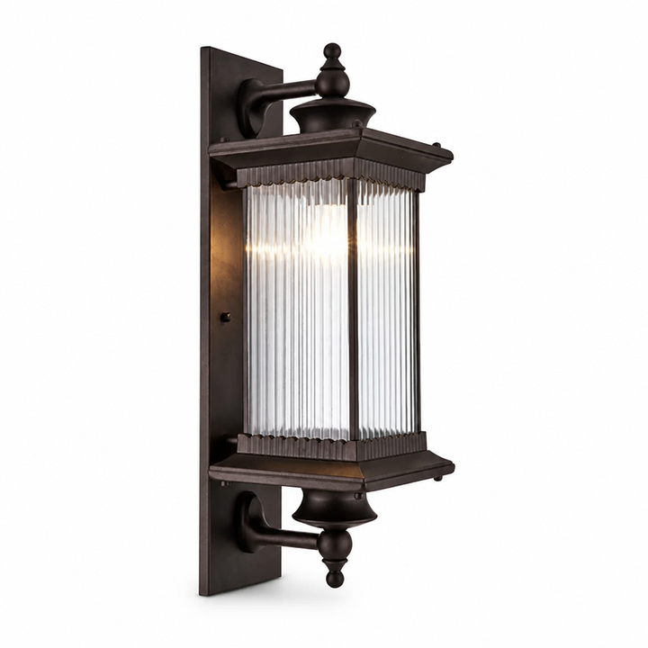 Outdoor wall light with ornate finials and ribbed glass panels, shown at an angle on white.