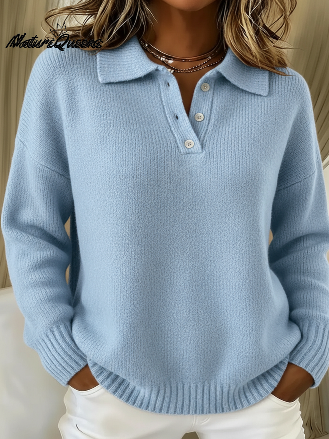 Light blue polo sweater with a three-button placket and ribbed knit, styled with white pants.
