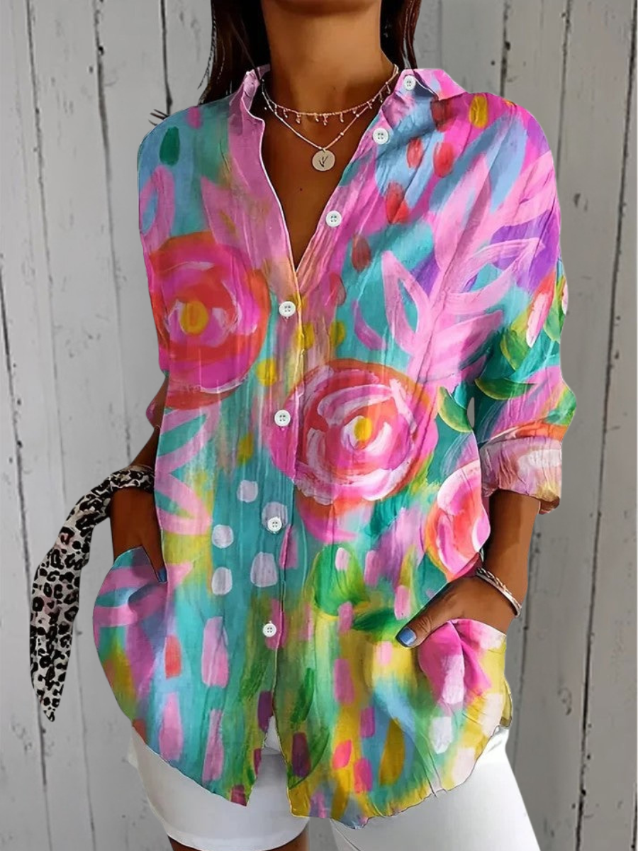 Anica blouse with a painterly print of large pink and orange roses on a teal and yellow ground.