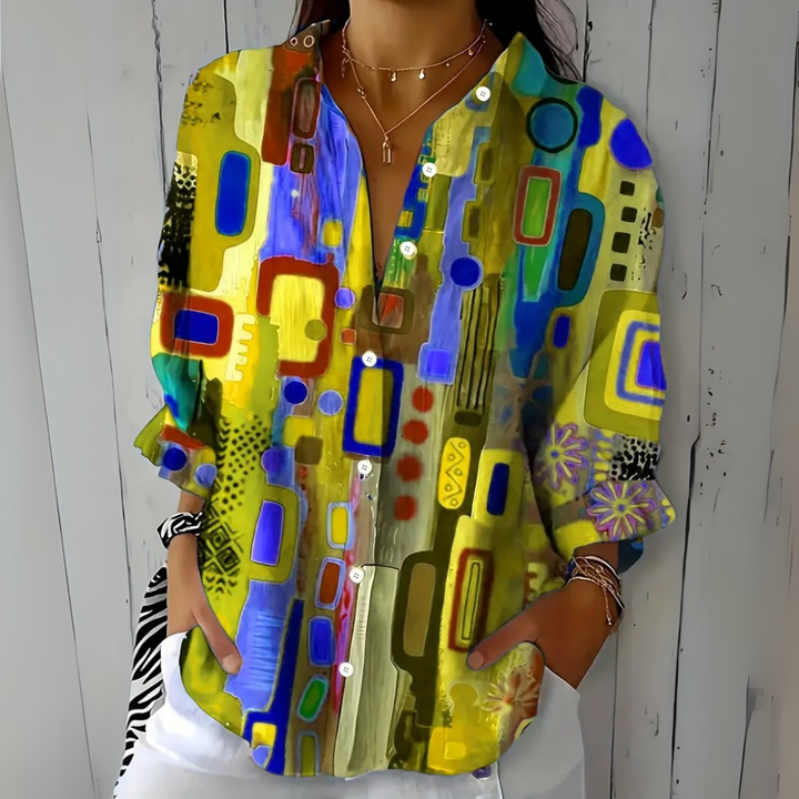 Front view of the yellow and blue colorway of the abstract-print blouse, buttoned partway.