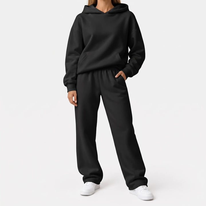 Full-length view of the black hoodie and wide-leg sweatpants on a model with white sneakers 6