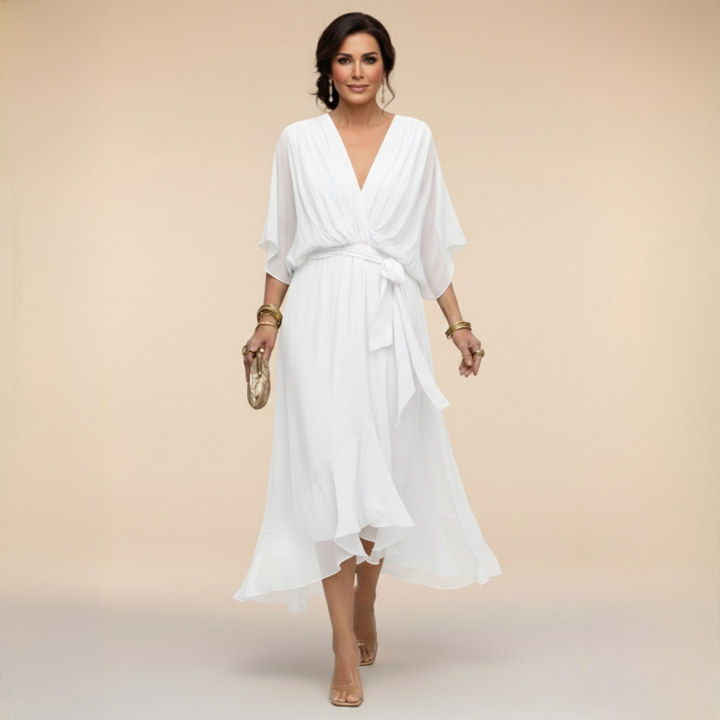 White midi dress detail with a V-neck, belted waist and ruffled asymmetric skirt.