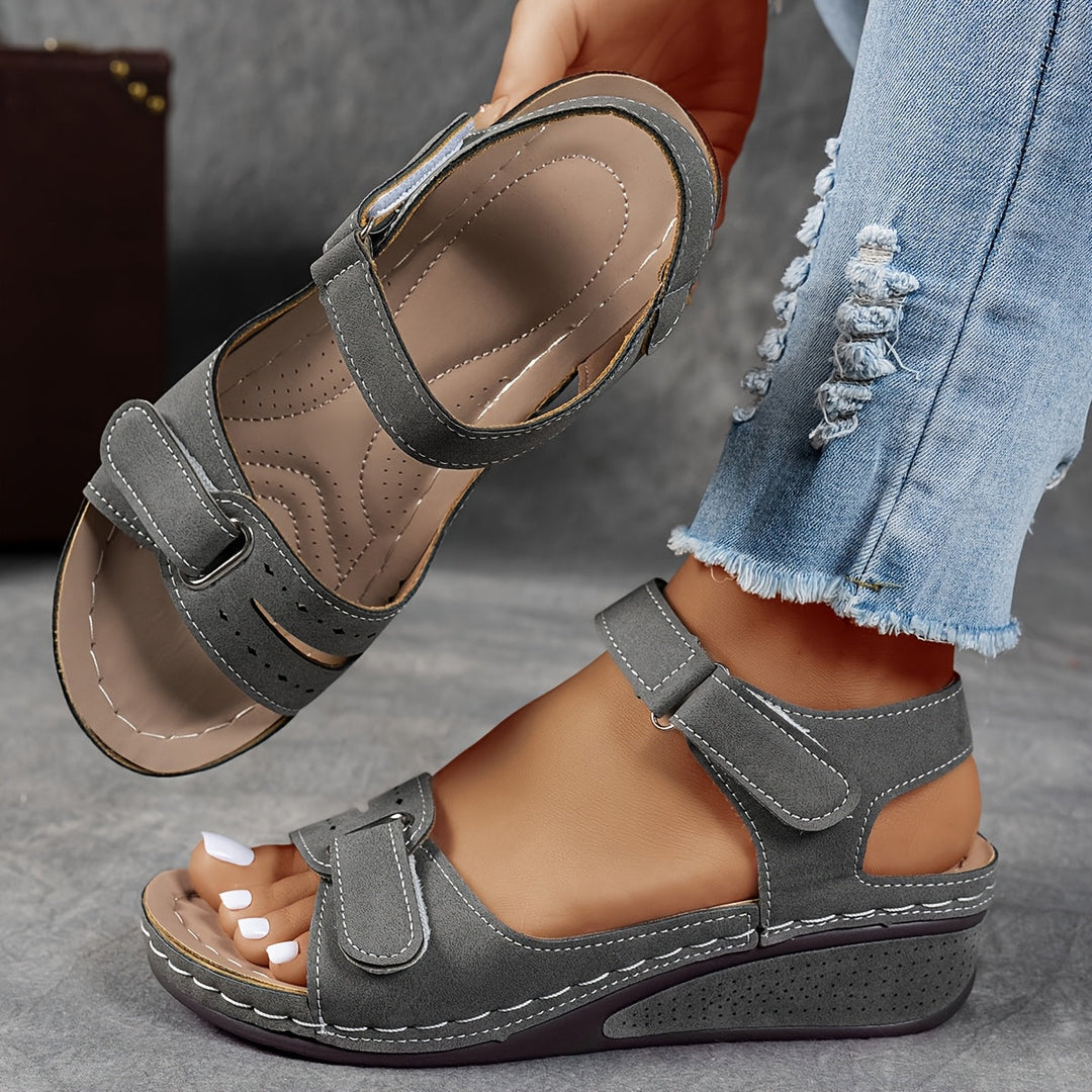 Gray wedge sandal with soft matte finish and adjustable straps, with the cushioned insole visible. 6
