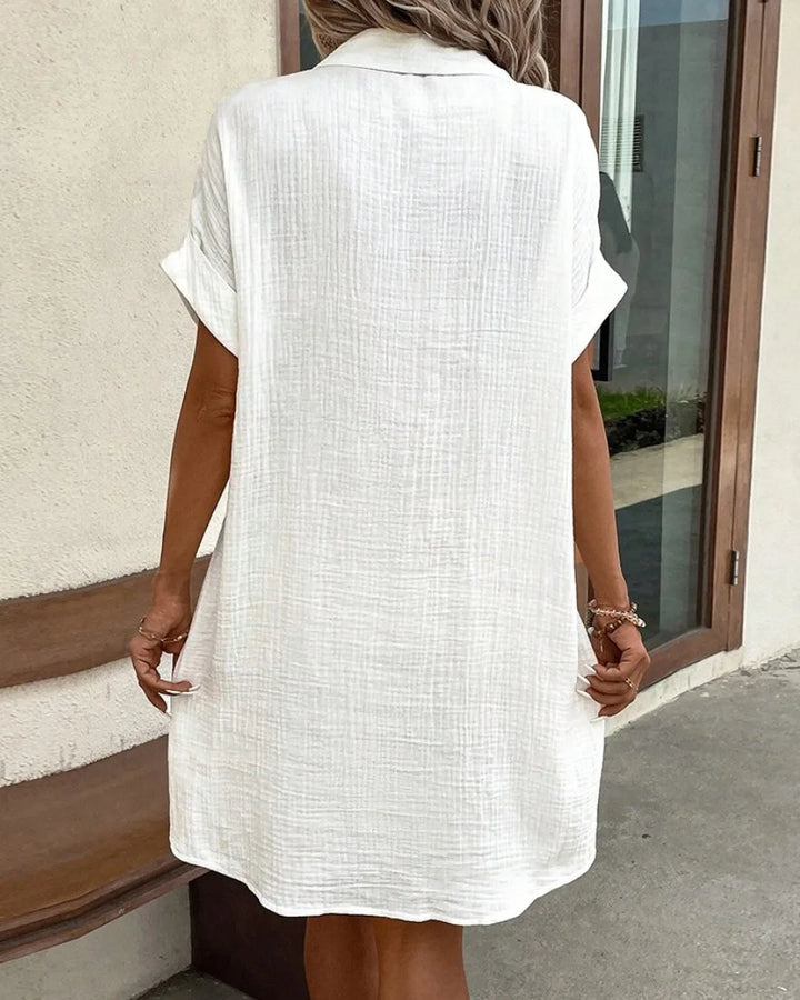 Back view of a white crinkled shirt dress with collar and cuffed short sleeves 6