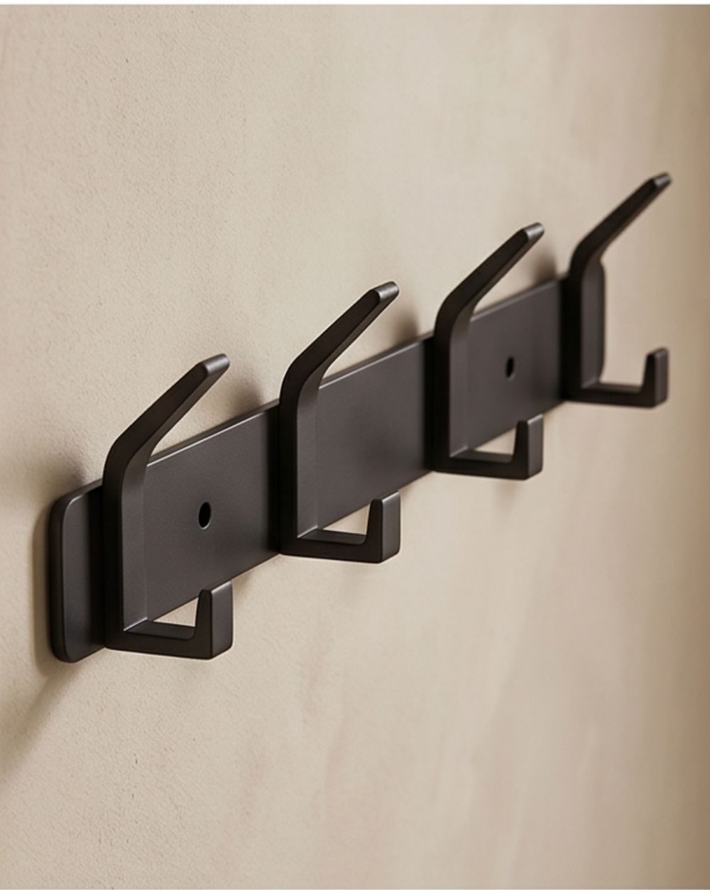 Black aluminum wall rack, another view, with screw holes in the flat bar on a plaster wall.