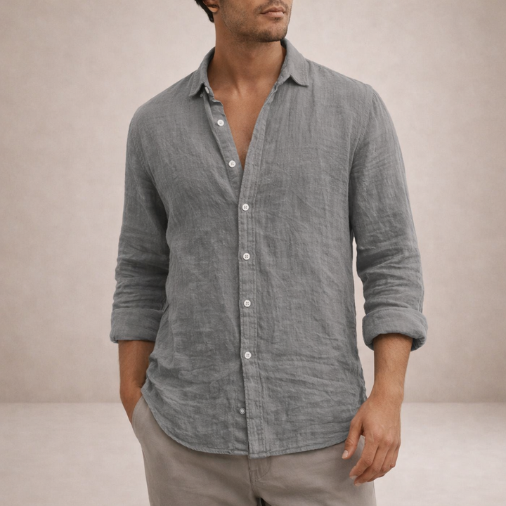 Model wearing the shirt in gray linen with a visible crinkled texture, one hand in a pocket.
