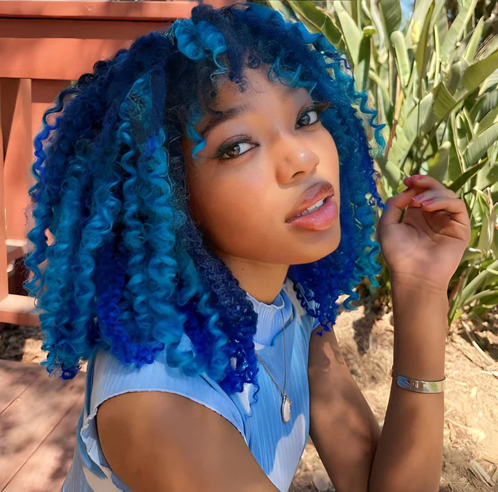 Blue curly hair with layered shades, worn with a light blue top.