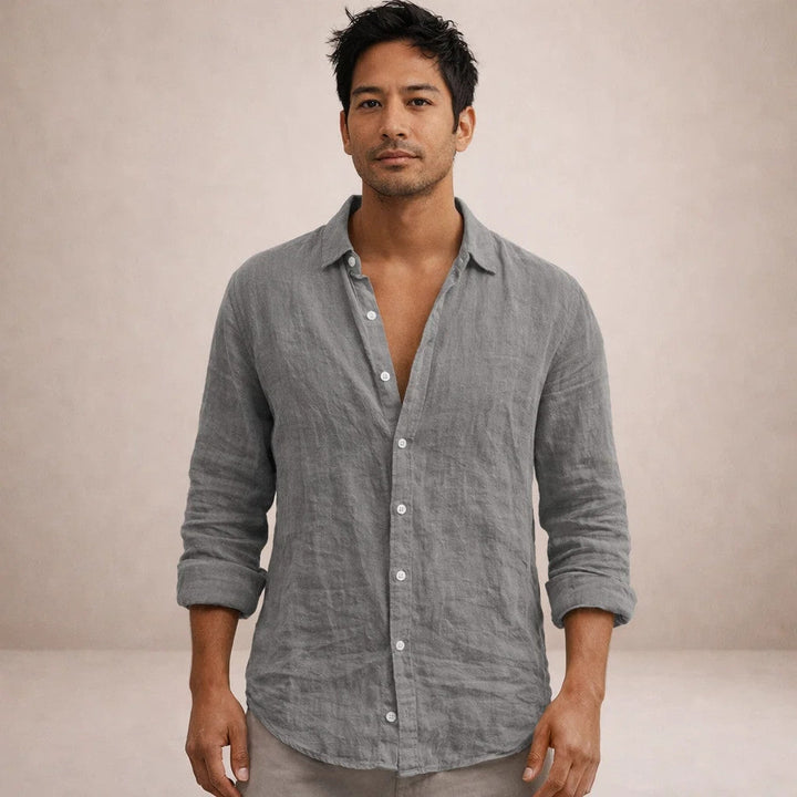 Model facing the camera in the gray linen shirt, collar open, sleeves rolled, softly wrinkled fabric.