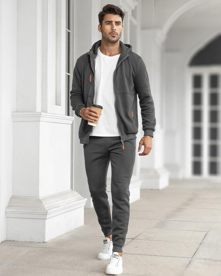 Model walking outdoors holding a coffee, wearing the gray hoodie open over a white tee with joggers 12
