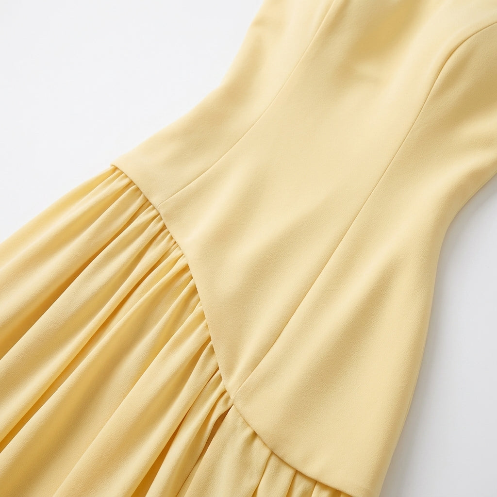 Close-up of the yellow bodice seams and asymmetric waistline.