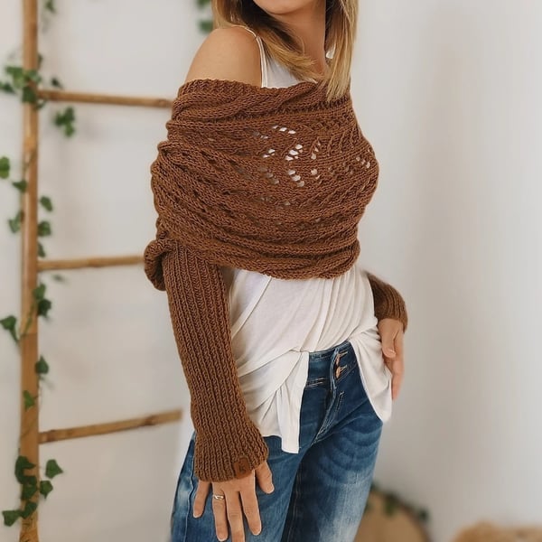 Brown knit wrap worn off one shoulder over a white top, with a long ribbed sleeve extending down the arm. 10