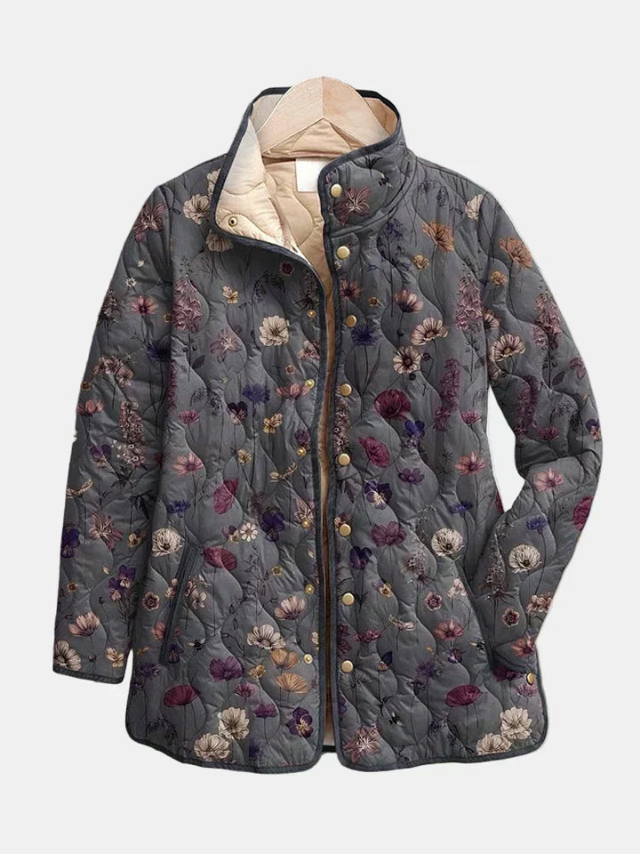 Grey quilted jacket with a purple and cream floral print and gold snap buttons, another view. 2