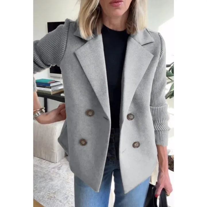 Light gray double-breasted jacket with ribbed knit sleeves, worn over a black top and jeans 7