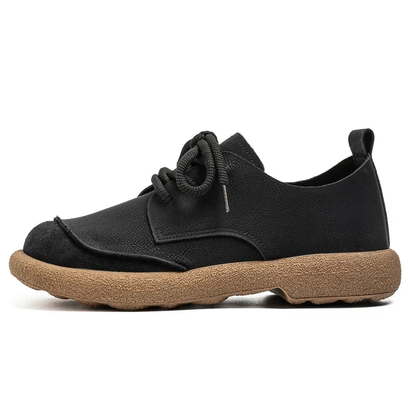 Side view of a black lace-up shoe with suede toe cap and tan sole 7