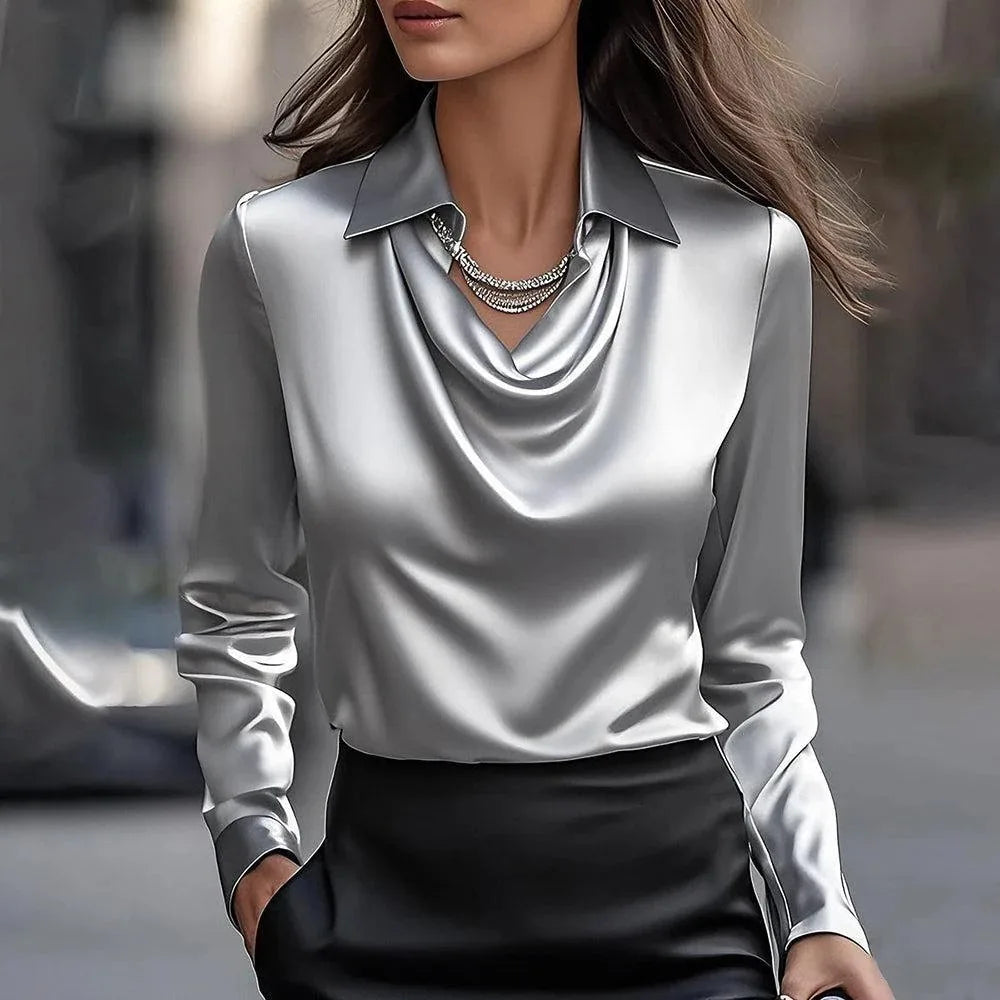 Glossy silver-gray satin blouse with draped collar and layered necklace, paired with a black skirt 7