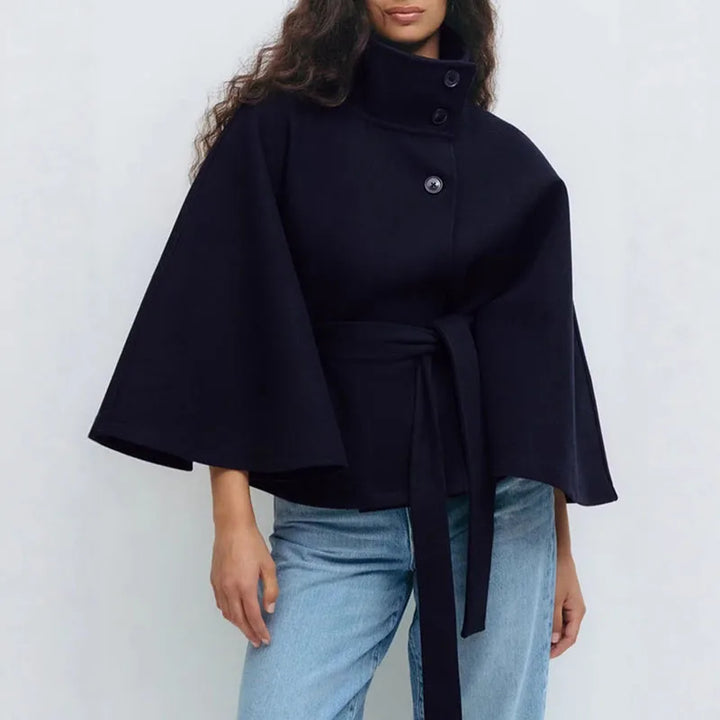 Navy cape jacket with flared sleeves and belt, worn by a model with light blue jeans 7