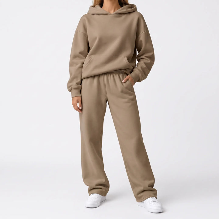 Full-length view of the tan hoodie and wide-leg sweatpants on a model with white sneakers 7