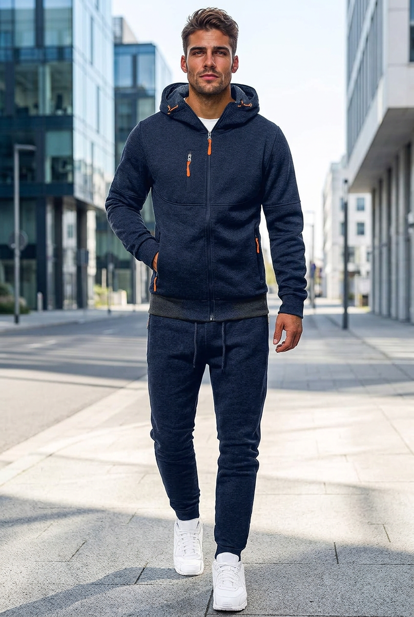 Man in a navy hooded zip jacket and jogger pants walking down a city street 1